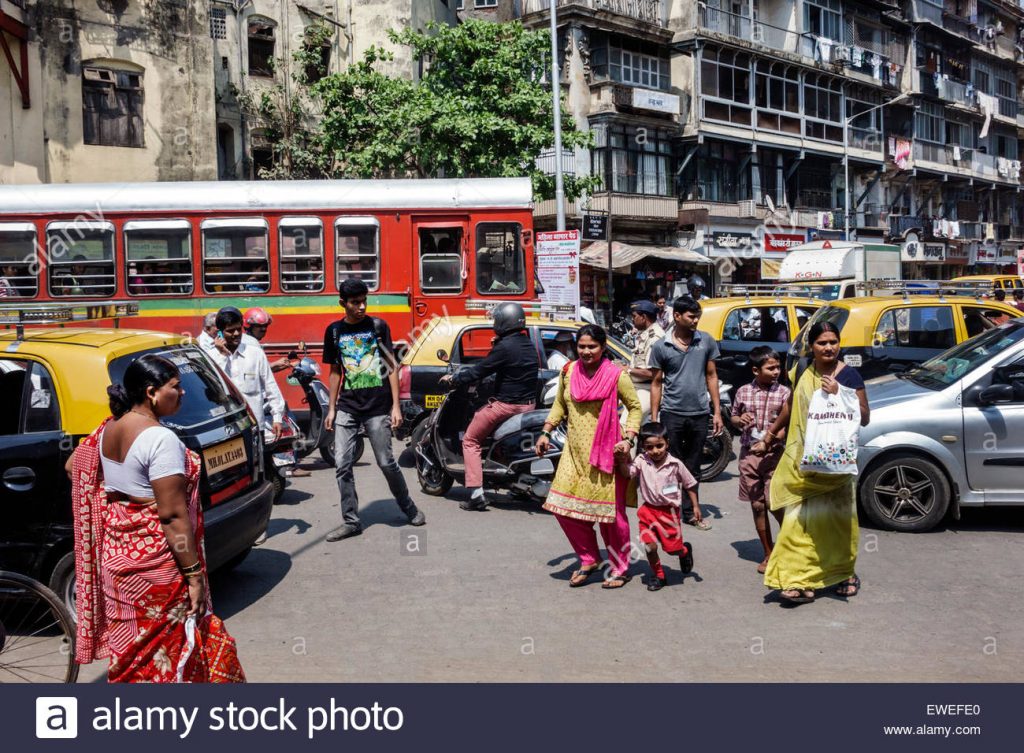 Pedestrians trying to cross the road in bustling traffic. 